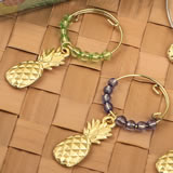 Set of four tropical gold pineapple wine charms decorated with different colored beads.